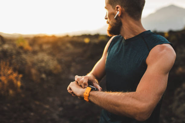 istock Athletic runner start training on fitness tracker or smart watch and looking forward on horizon. Trail running and active lifestyle concept. 1158317159