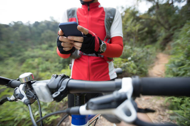 istock Riding on summer hill, holding mobile phone, using online application for searching GPS coordinates while riding bike in forest on sunny day 1158323550