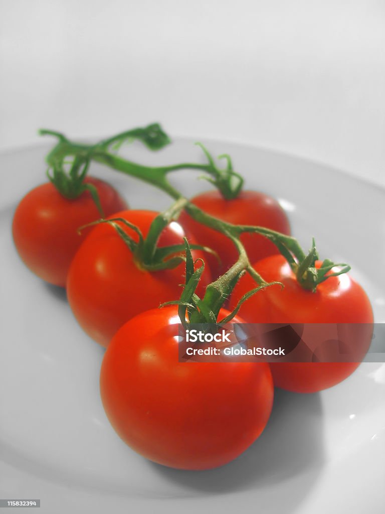 Tomatos en una placa - Foto de stock de Alimento libre de derechos