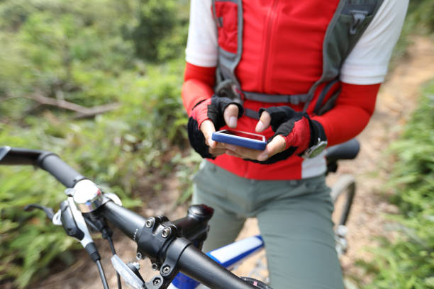 istock Riding on summer hill, holding mobile phone, using online application for searching GPS coordinates while riding bike in forest on sunny day 1158324076