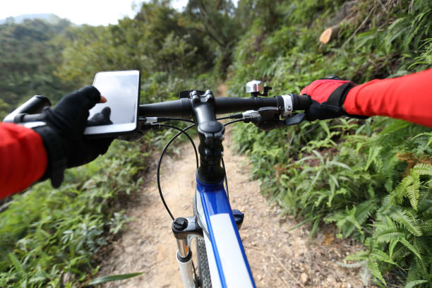 istock Riding on summer hill, holding mobile phone, using online application for searching GPS coordinates while riding bike in forest on sunny day 1158324600
