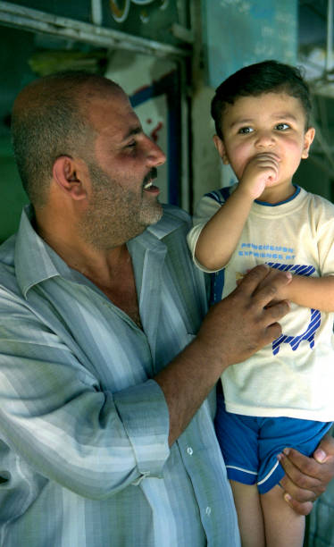Muslim people Iraq, Baghdad - 2 may 2005 Father holds his son in his arms iraqi kurdistan stock pictures, royalty-free photos & images