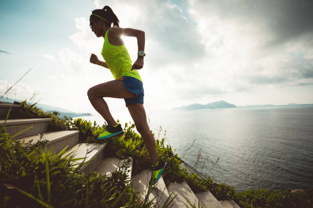 istock Determined woman running up on seaside mountain stairs 1158328554
