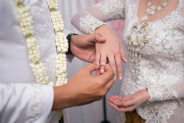Install Ring Pasang Cincin on Javanese Wedding. Traditional Javanese Groom Puts a Ring On The Bride indonesian ethnicity stock pictures, royalty-free photos & images