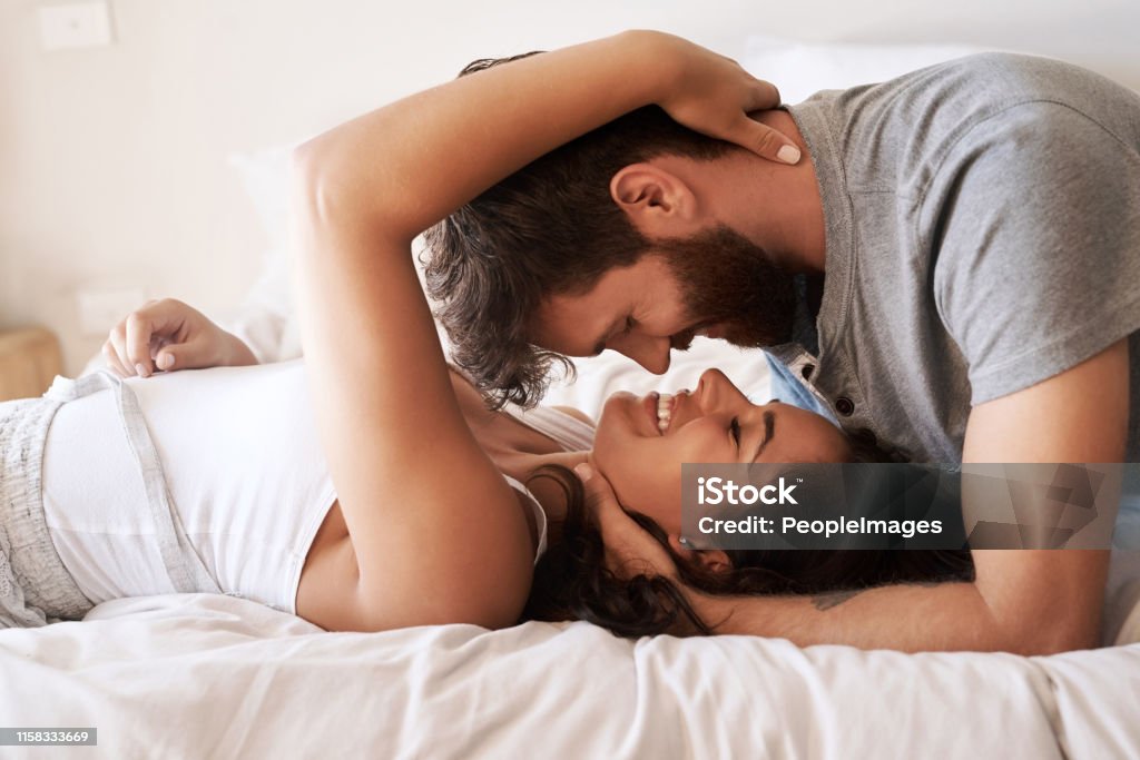 Nothing enriches life like love Shot of an affectionate young couple sharing a romantic moment in the bedroom at home Couple - Relationship Stock Photo
