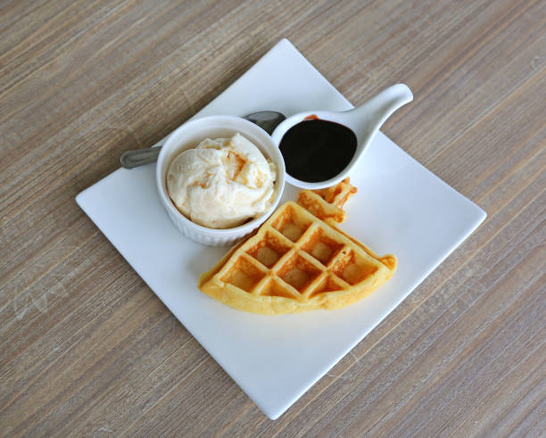 istock waffles served with ice cream and chocolate in white plate against wood table 1158333705