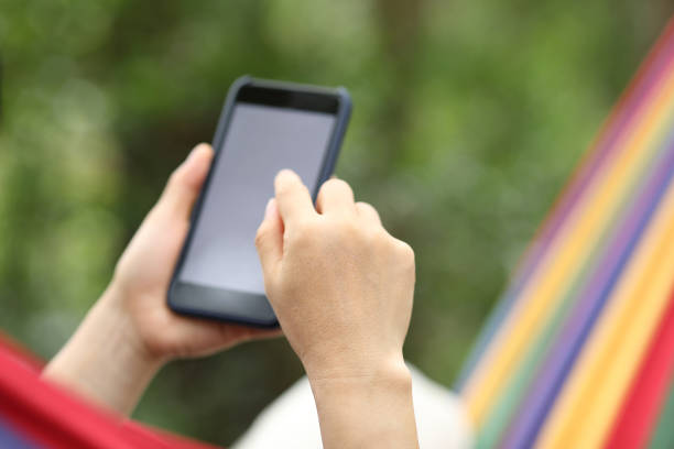 istock Relaxing in hammock with smartphone in forest 1158333782