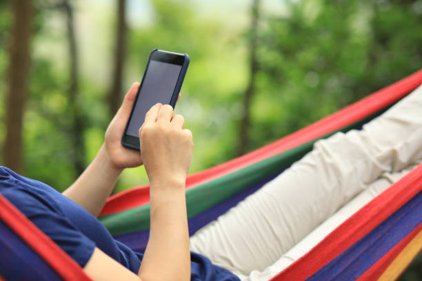 istock Relaxing in hammock with smartphone in forest 1158334167