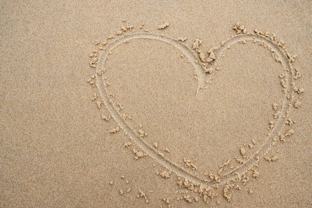 istock heart shape on the beach sand background. 1158335242