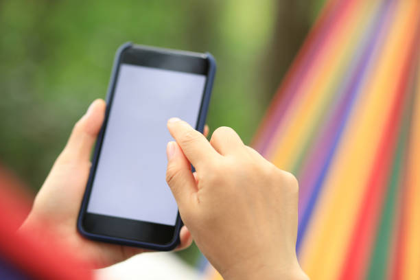 istock Relaxing in hammock with smartphone in forest 1158335250