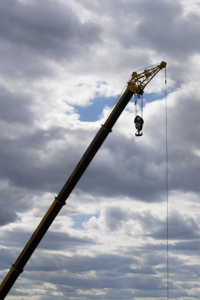istock Hoisting crane at a construction site against a cloudy sky 1158341446
