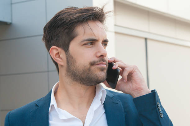 istock Serious confident businessman talking on mobile phone 1158342504