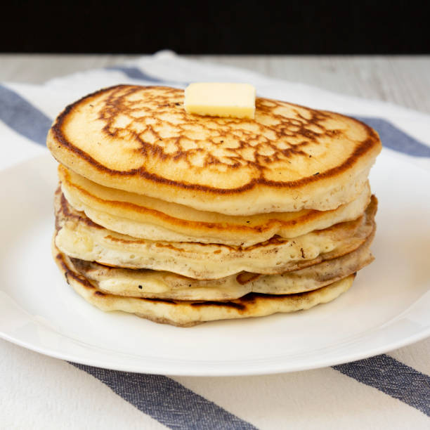 istock Homemade pancakes with butter on a white plate, side view. Closeup. 1158343205