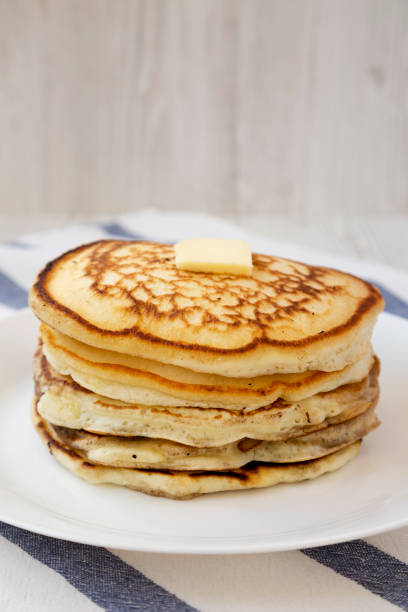 istock Homemade pancakes with butter on a white plate, side view. Close-up. 1158343256