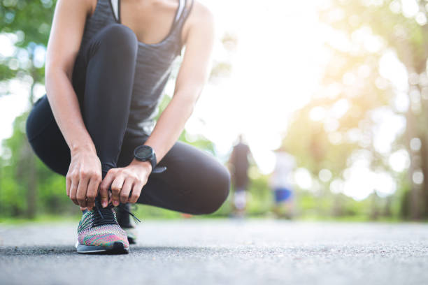istock Young woman tying jogging shoes. 1158343652