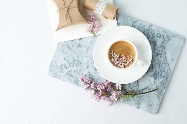 istock Minimalistic still life with coffee and lilac branches on marble plate and the white table, morning female concept, copy space 1158343683