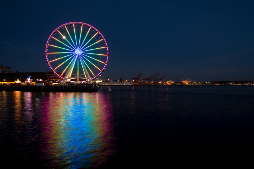Seattle, USA - Jun 15, 2019: The ferris wheel illuminated with the LGBT rainbow at twilight.