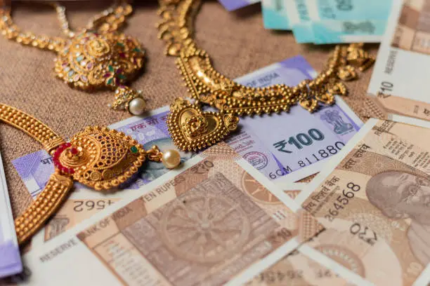 Photo of Concept of black money, IT raid, confiscated or unaccounted Money showing Indian currency notes with jewelry