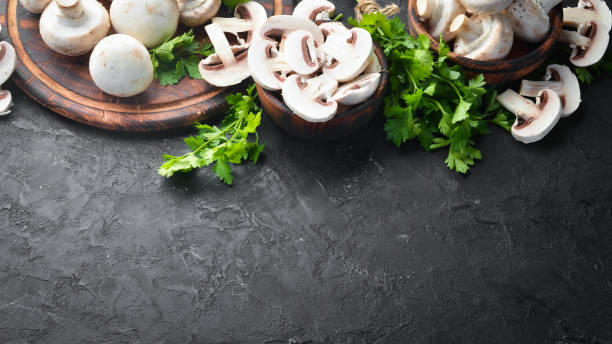 istock Mushrooms sliced on a black table surface. Top view. Free space for text. 1158353764