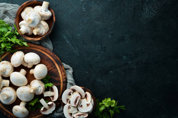 istock Mushrooms sliced on a black table surface. Top view. Free space for text. 1158353920
