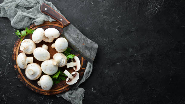istock Mushrooms sliced on a black table surface. Top view. Free space for text. 1158353988