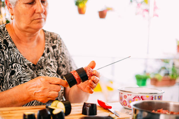 Portrait of a mature Latin woman cooking at home - Preparing Albondigas Mexican food