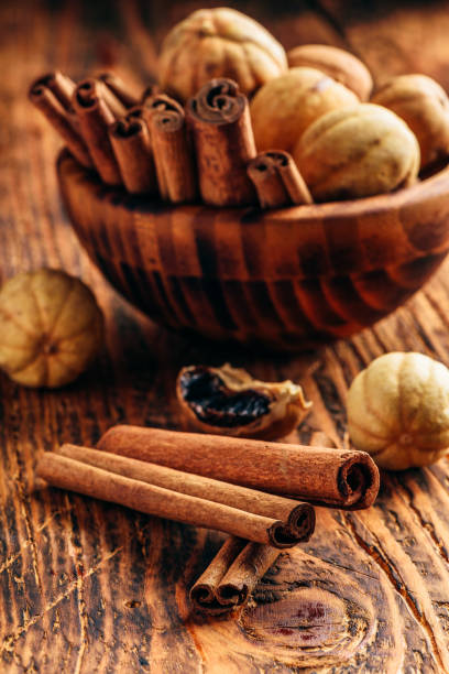 istock Cinnamon sticks and dried limes in wooden bowl 1158355111