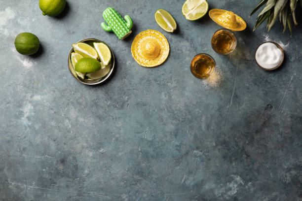 Tequila and lime slices on a blue background. Selective focus.