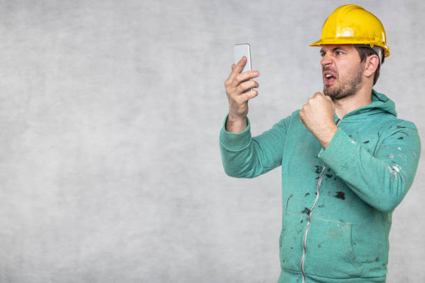 istock A construction supervisor is screaming into a cell phone, clenching a fist 1158358175