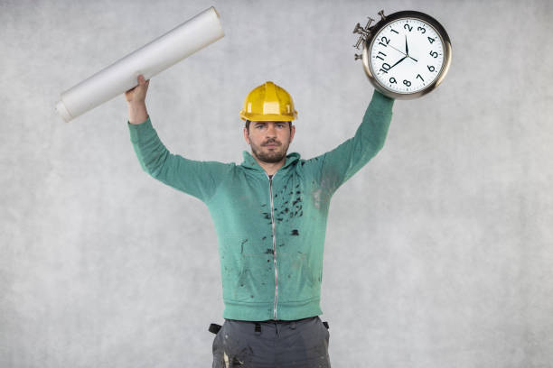 istock the builder is holding plans and a watch in his hand 1158358792