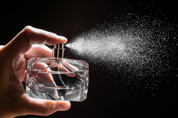 sprühen parfüm auf dunklen hintergrund, nahaufnahme - bild - parfüm stock-fotos und bilder
