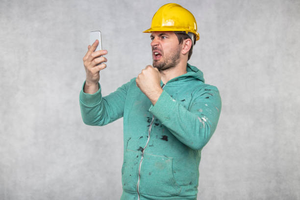 istock construction supervisor is shouting to a cell phone, copy space next to him 1158358961