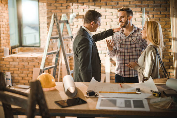 istock Smiling architect talking to couple during home improvement process. 1158375132