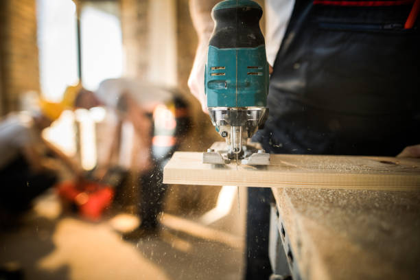 istock Close up of unrecognizable worker cutting plank with circular saw at construction site. 1158378817