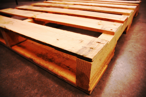 A close-up of large stacks of used wooden pallets.
