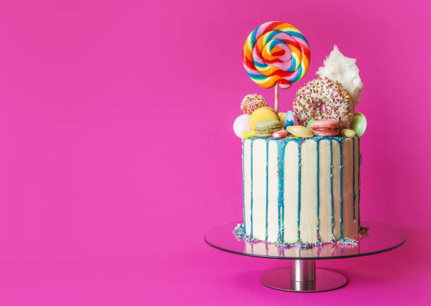 bolo colorido do gotejamento dos doces, fundo cor-de-rosa, direito tomado o partido, com espaço da cópia - gateaux cake birthday decorating - fotografias e filmes do acervo
