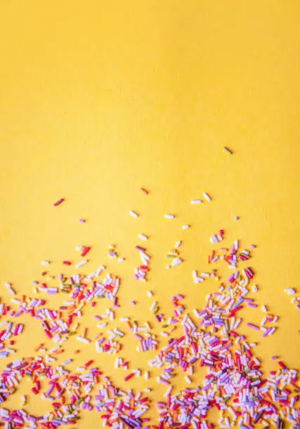 Photo of Colorful sprinkle texture background, yellow, vertical, with copy space