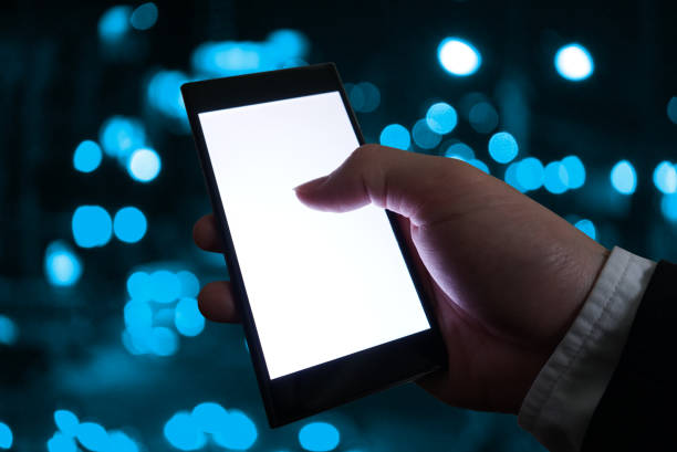 istock White screen smart phone on businessman 's hand with blue bokeh  background 1158384600
