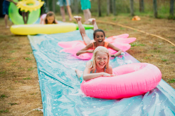 crianças que têm o divertimento em um deslizamento ' n' slide - inflatable slide sliding child - fotografias e filmes do acervo