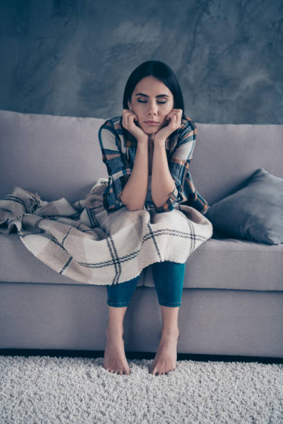istock Vertical full length body size side profile photo beautiful she her lady fell asleep while sitting hands arms hold head covered blanket wear checkered plaid shirt divan flat house living room indoors 1158388935