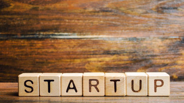 istock Wooden blocks with the word Startup. Temporary structure designed to find and implement a scalable business model. The concept of raising funds for a startup. Crowdfunding. Investing in the future. 1158389146