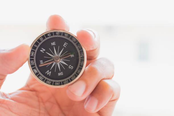 istock man holding compass on blurred background. for activity lifestyle outdoors freedom or travel tourism and inspiration backpacker alone tourist travel or navigator image. 1158389295