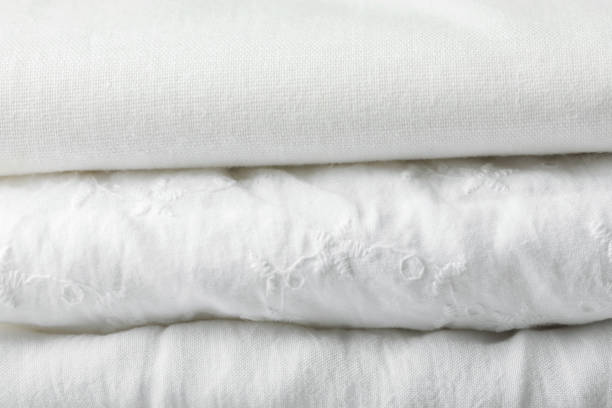 istock Stack of pure organic cotton and linen folded fabric plane and with eyelet lace pattern. Clothing laundry home textile concept. Poster banner with copy space 1158389493