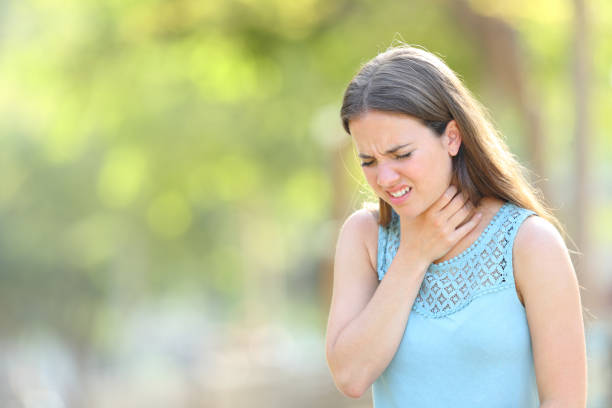 istock Woman suffering sore throat in a park 1158391902