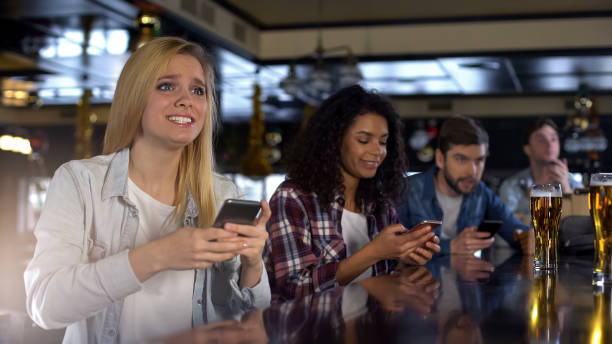 istock Anxious fans making sport bets in bookmaker mobile app in bar watching game live 1158393813