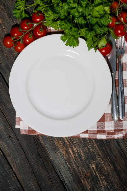 istock table setting with white plate and vegetables on wooden background, vertical top view 1158393826