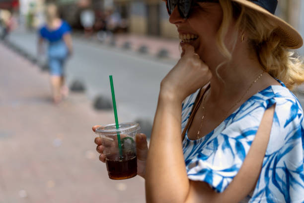 istock Woman in hat is drinking cold coffee 1158394532