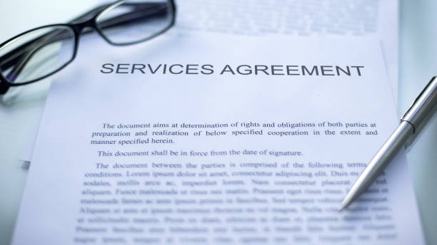 istock Services agreement lying on table, pen and eyeglasses on official document 1158394627