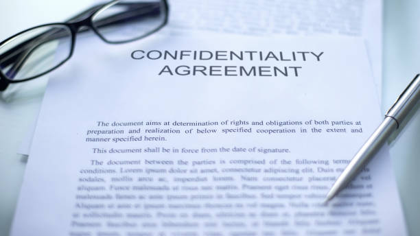 istock Confidentiality agreement, lying on table, pen and eyeglasses on document 1158394712