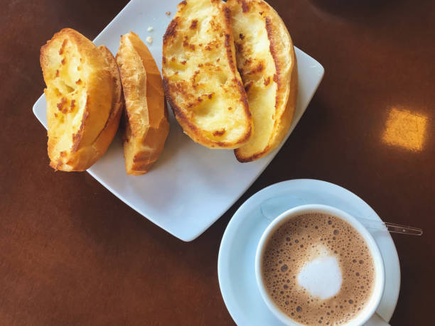 istock Brazilian breakfast.  Capuccino cup and toasted bread with butter background. 1158395372